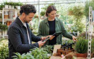 Zwei Geschäftspartner prüfen in einem österreichischen Gartencenter gemeinsam eine Empfehlungsplatzierung